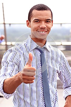 Smiling african businessman with thumbs up