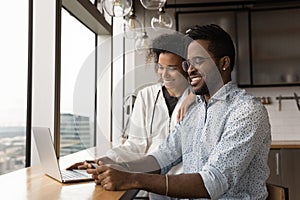 Smiling african couple pay for goods check bank account online