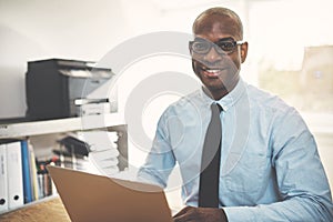 Smiling African entrepreneur working online in a home office