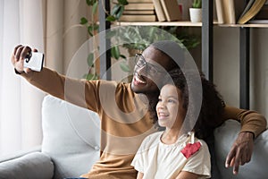 Smiling african family dad and daughter make selfie photo