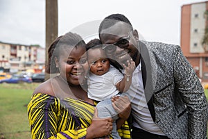 Smiling African family, six month old baby in the middle of mother and father