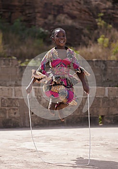 Smiling African Girl Jumping High With Her Skipping Rope With Both Legs At A Time