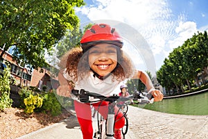 Smiling African girl riding her bicycle in summer