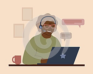 A smiling African grandmother in headphones with a laptop. An elderly woman communicates, studies, works or shoppes