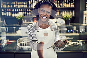 Smiling African hostess offering a handshake in her trendy cafe