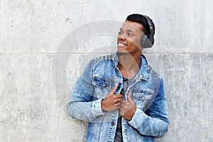 Smiling african man listening to music on wireless headphones
