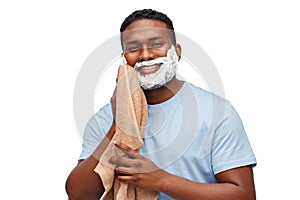 Smiling african man with shaving cream and towel