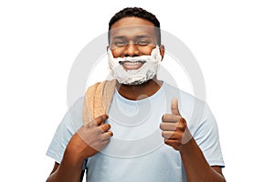 Smiling african man with shaving foam and towel