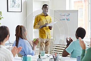 Smiling African Man Standing by Whiteboard in Meeting