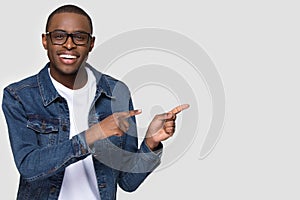 Smiling african man wearing glasses looking at camera pointing aside