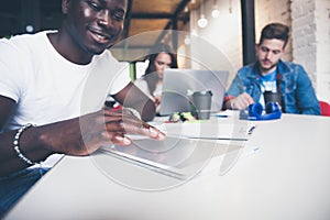 Smiling African man using tablet for video conversation in modern office.