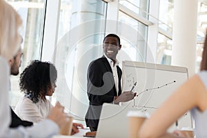 Smiling african mentor giving presentation at office training