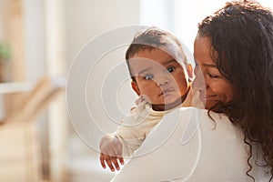 Smiling African mom holding baby