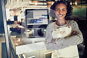 Smiling African waitress standing at the counter of a restaurant photo