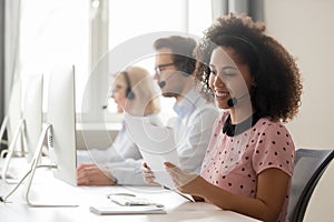 Smiling african woman call center operator wearing headset reading papers photo