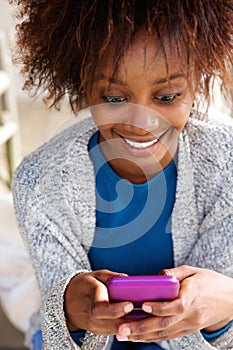 Smiling african woman holding mobile phone