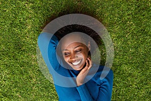 Smiling african woman lying on grass