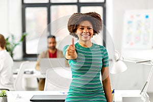 Smiling african woman showing thumbs up at office