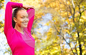 Smiling african woman stretching hand outdoors