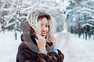 Smiling afro american girl wearing in fur coat in winter park