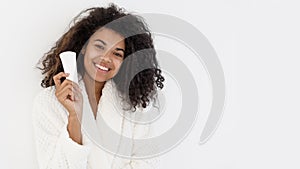 Smiling afro american woman holding tube with cosmetics cream