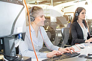 Smiling agent woman with headsets. Portrait of call center worker at office.