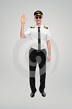 Smiling airline pilot man waving hand and smiling