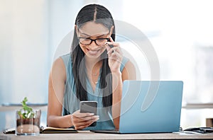 Smiling ambitious mixed race businesswoman sitting alone at a desk in the office and browsing the internet on her