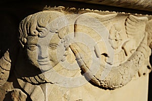 A smiling angel`s head on the corner of a tombstone from the Biedermeier period