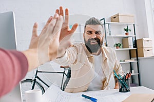 Smiling architect giving high five to coworker