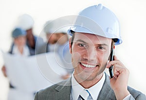 Smiling architect with a hardhat on phone