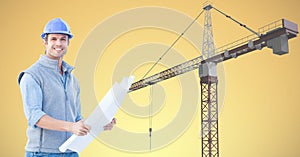 Smiling architect holding blueprint against crane