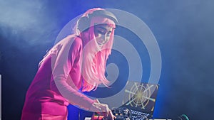 Smiling artist standing at dj table playing electronic music