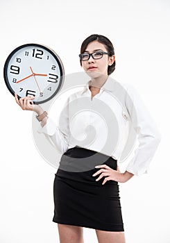 Smiling asian business woman in eyeglasses holding clock and looking at the camera over white background with clipping path