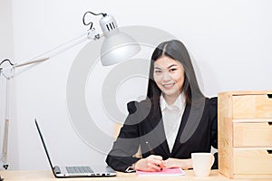 Smiling asian businesswoman with laptop computer posting in whit