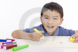 Smiling asian child schoolboy painting and drawing at home