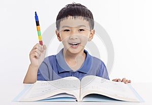 Smiling asian child schoolboy studying and drawing at home