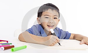 Smiling asian child schoolboy studying and drawing at home photo