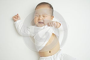 Smiling Asian Chinese baby pulling her shirt playfully