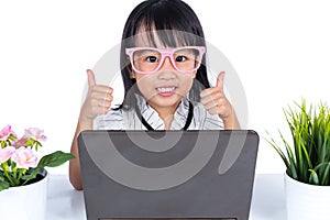 Smiling Asian Chinese little girl using laptop with thumbs up