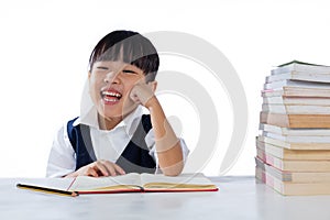 Smiling Asian Chinese little girl wearing school uniform studying