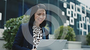 Smiling Asian Female Coach Making Online Lecture Sitting Outside with Laptop