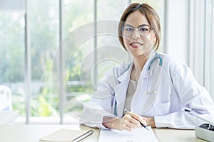 Smiling asian female doctor in the office , Portrait of beautiful mature woman doctor is committed to treating patients. healtcare