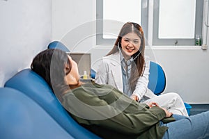 smiling Asian female doctor using a stethoscope while examining a patient