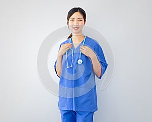 Smiling Asian female doctor wearing blue hospital uniform