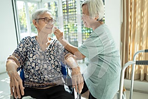 Smiling asian female elderly person wipe sweat on the skin face of the senior sister and talk happily,old people visited her  aged photo