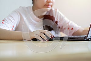 Smiling Asian female freelancer sitting and read a document online correspond with client in chat on her laptop