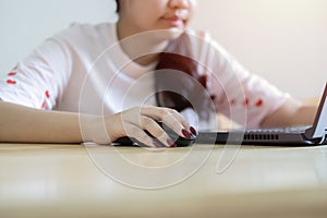 Smiling Asian female freelancer sitting and read a document online correspond with client in chat on her laptop photo