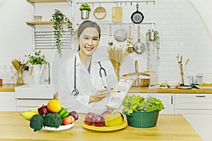 Smiling Asian female nutritionist holding a healthy eating and diet graph document.