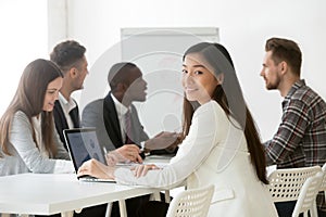 Smiling Asian female posing to camera working during briefing